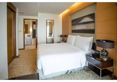 a bedroom with a large white bed and a bathroom at Dubai Mall Residences -Luxury 1 bedroom in Dubai