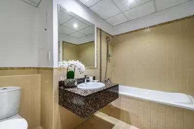 a bathroom with a sink and a tub and a toilet at The Smart Concierge - Bahar 1 in Dubai