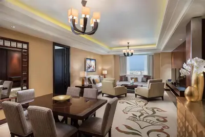a living room with a dining table and chairs at Conrad Dubai in Dubai