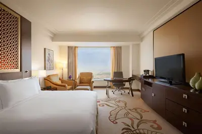 a hotel room with a bed and a television at Conrad Dubai in Dubai