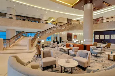 a lobby of a hotel with tables and chairs at Conrad Dubai in Dubai