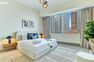 a bedroom with a white bed and a large window at bnbme - Dubai Marina 54th Floor Apt Sea View Two Balconies Pool Gym & Parking in Dubai