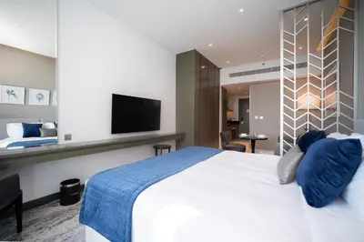 a hotel room with a bed and a tv at Luton Vacation Homes - Damac Maison Prive Studio, Canal View, Dubai - 16AB03 in Dubai