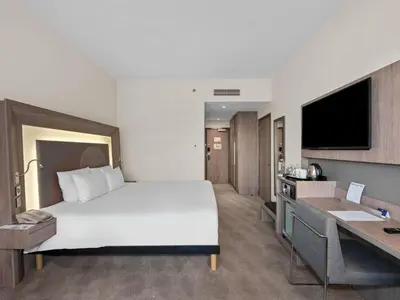 a hotel room with a large bed and a desk at Novotel Dubai World Trade Centre in Dubai
