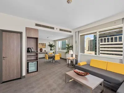 a living room with a couch and a table at Novotel Dubai World Trade Centre in Dubai