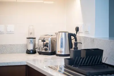 a kitchen counter with a coffee maker and a toaster at HiGuests - Chic Apt with Balcony and Pool near Burj Khalifa in Dubai
