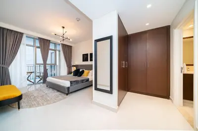 a bedroom with a bed and a mirror at HiGuests - Chic Apt with Balcony and Pool near Burj Khalifa in Dubai