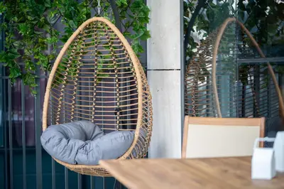 a chair with a blue pillow in a basket at HiGuests - Chic Apt with Balcony and Pool near Burj Khalifa in Dubai