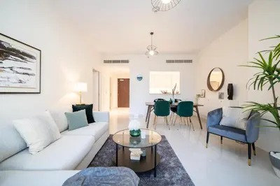 a living room with a couch and a table at HiGuests - Chic Apt with Balcony and Pool near Burj Khalifa in Dubai