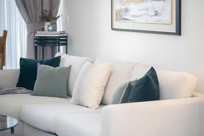 a white couch with pillows on it in a living room at HiGuests - Chic Apt with Balcony and Pool near Burj Khalifa in Dubai