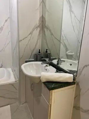 a white bathroom with a sink and a mirror at skynest homes studio in JLT in Dubai
