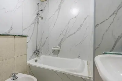 a white bathroom with a white tub and a sink at skynest homes studio in JLT in Dubai