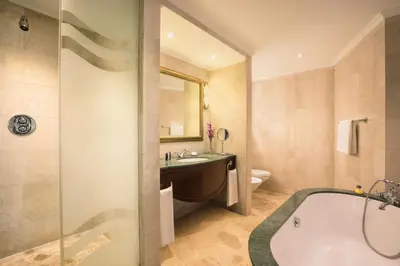a bathroom with a tub and a sink and a toilet at JA Beach Hotel, Dubai in Dubai