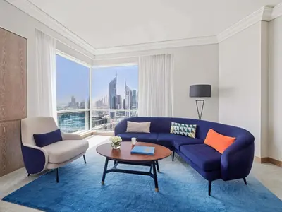 a living room with a blue couch and a table at Fairmont Dubai in Dubai