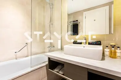 a bathroom with a white sink and a shower at Staycae Holiday Homes - Prive in Dubai