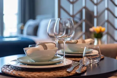 a table with plates and wine glasses on a table at The Smart Concierge - Damac Maison Prive in Dubai