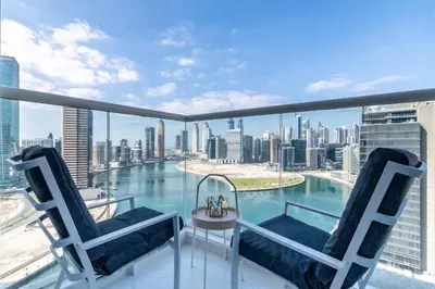 a balcony with chairs and a view of the city at The Smart Concierge - Damac Maison Prive in Dubai