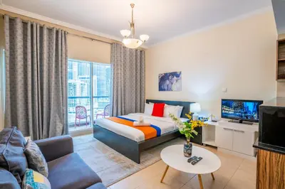 a bedroom with a king sized bed and a living room at RH- Perfect Downtown Getaway for Couple, Near Dubai Mall in Dubai