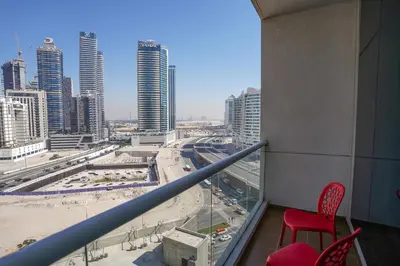 a view of a city from a balcony with a red chair at RH- Perfect Downtown Getaway for Couple, Near Dubai Mall in Dubai