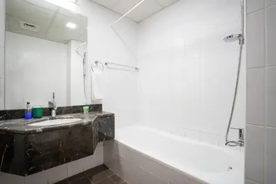 a bathroom with a sink and a tub and a mirror at RH- Perfect Downtown Getaway for Couple, Near Dubai Mall in Dubai