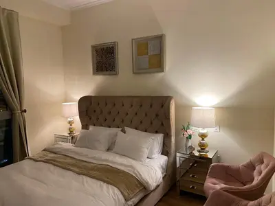 a bedroom with a bed and two lamps and a chair at Luxury 1br in Dubai Marina, ask for July Full month offer in Dubai