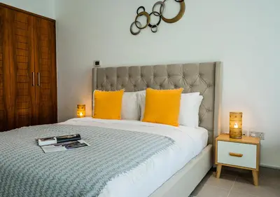 a bedroom with a large bed with orange pillows at Nasma Luxury Stays - Boulevard Central Tower in Dubai