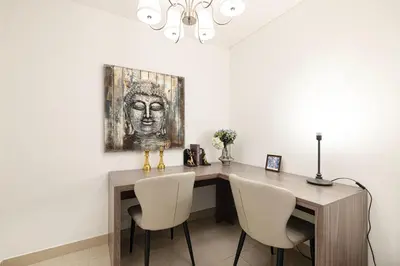 a desk with two chairs and a painting on the wall at FIRST CLASS 3BR Burj Khalifa & Fountain View in Dubai