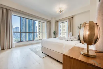 a bedroom with a large bed and large windows at Glamorous 1BR Apartment in Rimal 3 Jumeirah Beach Residence by Deluxe Holiday Homes in Dubai