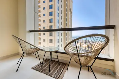 a table and two chairs in a room with a window at Glamorous 1BR Apartment in Rimal 3 Jumeirah Beach Residence by Deluxe Holiday Homes in Dubai