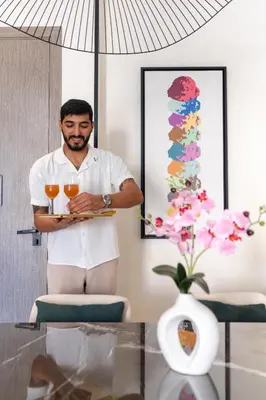 a man holding two glasses of wine in a room at Th8 Palm Dubai Beach Resort, Vignette Collection by IHG in Dubai