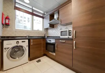 a kitchen with a washing machine and a microwave at City Stay Residences - Serviced Apartments Al Barsha in Dubai