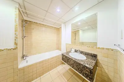 a bathroom with a sink and a tub and a mirror at Brand new Rimal 2BD in front of The JBR Beach in Dubai