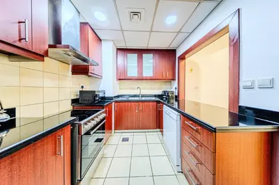 a kitchen with red cabinets and a sink at Brand new Rimal 2BD in front of The JBR Beach in Dubai