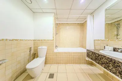 a bathroom with a toilet and a tub and a sink at Brand new Rimal 2BD in front of The JBR Beach in Dubai
