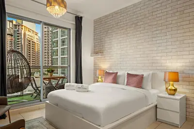 a bedroom with a white bed and a brick wall at FIRST CLASS 1BR Spectacular Fountain Views in Dubai