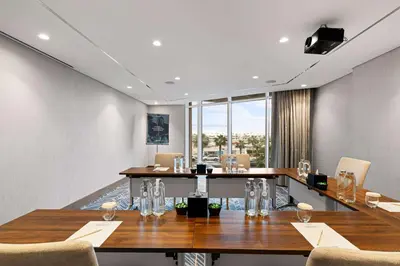 a conference room with a long table and chairs at Radisson Dubai Damac Hills in Dubai