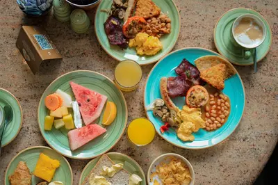 a table with plates of breakfast food on it at Radisson Dubai Damac Hills in Dubai