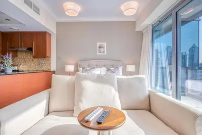 a living room with a couch and two remote controls on a table at Prime Retreats - Downtown Dubai in Dubai