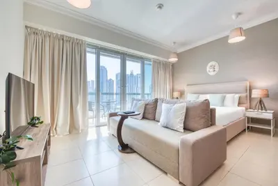 a living room with a bed and a large window at Prime Retreats - Downtown Dubai in Dubai