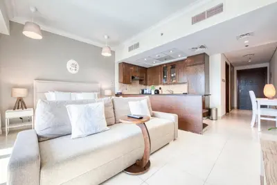 a living room and kitchen with a couch and a table at Prime Retreats - Downtown Dubai in Dubai