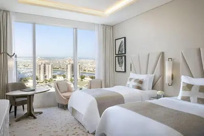 a hotel room with two beds and a window at The St. Regis Dubai, The Palm in Dubai