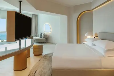 a bedroom with a bed and a desk with a television at Sheraton Jumeirah Beach Resort in Dubai