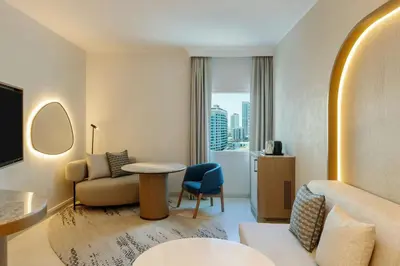 a hotel room with a couch chair and a table at Sheraton Jumeirah Beach Resort in Dubai