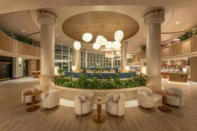 a lobby with a large fountain with tables and chairs at Sheraton Jumeirah Beach Resort in Dubai
