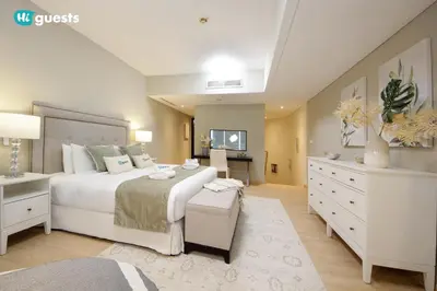 a bedroom with a large white bed and a desk at HiGuests - Fabulous Duplex With Breathtaking Lake Views in Dubai