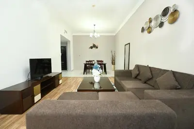 a living room with a couch and a tv at Al Waleed Holiday Homes in Dubai