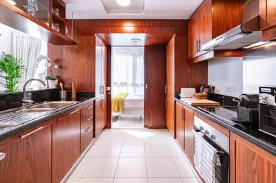 a kitchen with wooden cabinets and a sink at Elite Royal Apartment - Full Burj Khalifa & Fountain View - Sapphire in Dubai