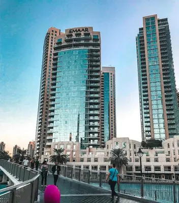 people walking on a bridge in a city with tall buildings at Elite Royal Apartment - Full Burj Khalifa & Fountain View - Sapphire in Dubai