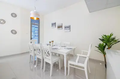 a white dining room with a white table and chairs at Charming 3 BR with walking distance to the Beach in Dubai