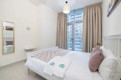 a bedroom with a white bed with pillows and a window at Charming 3 BR with walking distance to the Beach in Dubai
